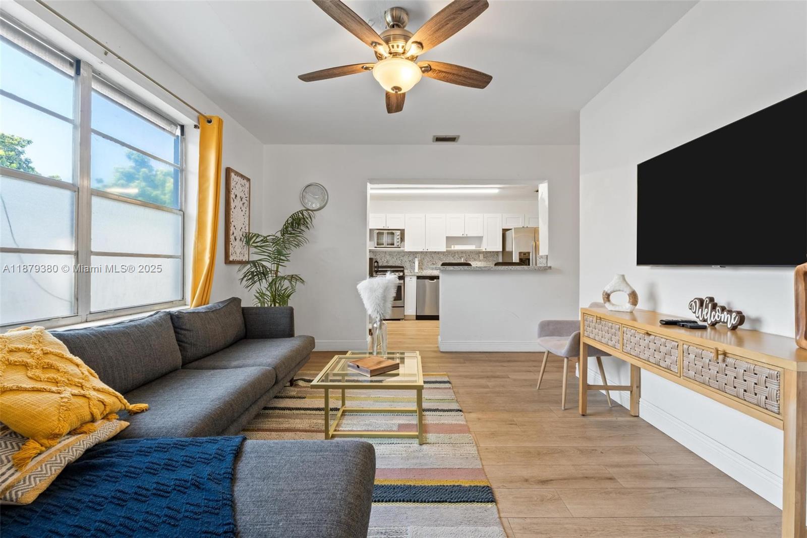 A living room features a grey sofa, a glass coffee table, and an open kitchen — 2453 SW 17th St # 2453, Miami FL 33145, MIAMI, FL