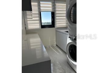 A laundry room features a stacked washer and dryer, white countertops, and a window — D-10 MANSIONES DE GARDEN HILLS UNIT D-10, GUAYNABO, PR