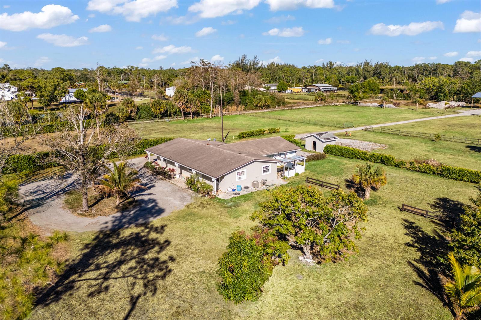 An aerial view shows a single-story house with a brown roof on a grassy lot — 1216 C Road, FL 33470, FL