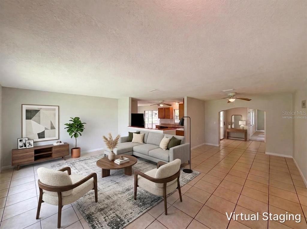 A living room with tile floors, a sectional sofa, two armchairs, and a coffee table — 6309 SHERMAN TERRACE, SEBRING, FL