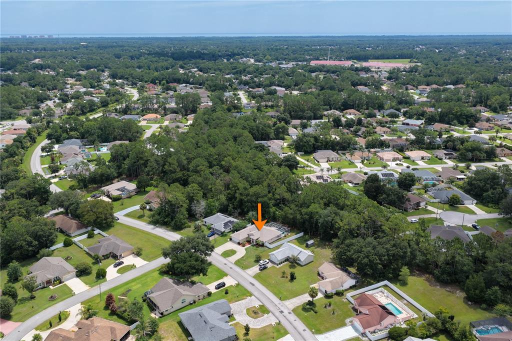 An aerial view shows a suburban neighborhood with a single-family home marked by an arrow — 137 WYNNFIELD DRIVE, PALM COAST, FL