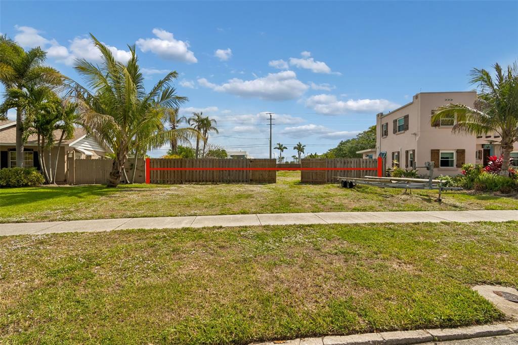 A vacant, grassy residential lot features a wooden fence spanning the middle of the property — 603 CASABELLA DRIVE, BRADENTON, FL