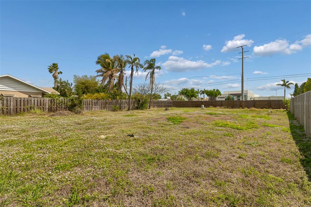 A vacant, grassy lot is enclosed by wooden fences under a blue sky — 603 CASABELLA DRIVE, BRADENTON, FL
