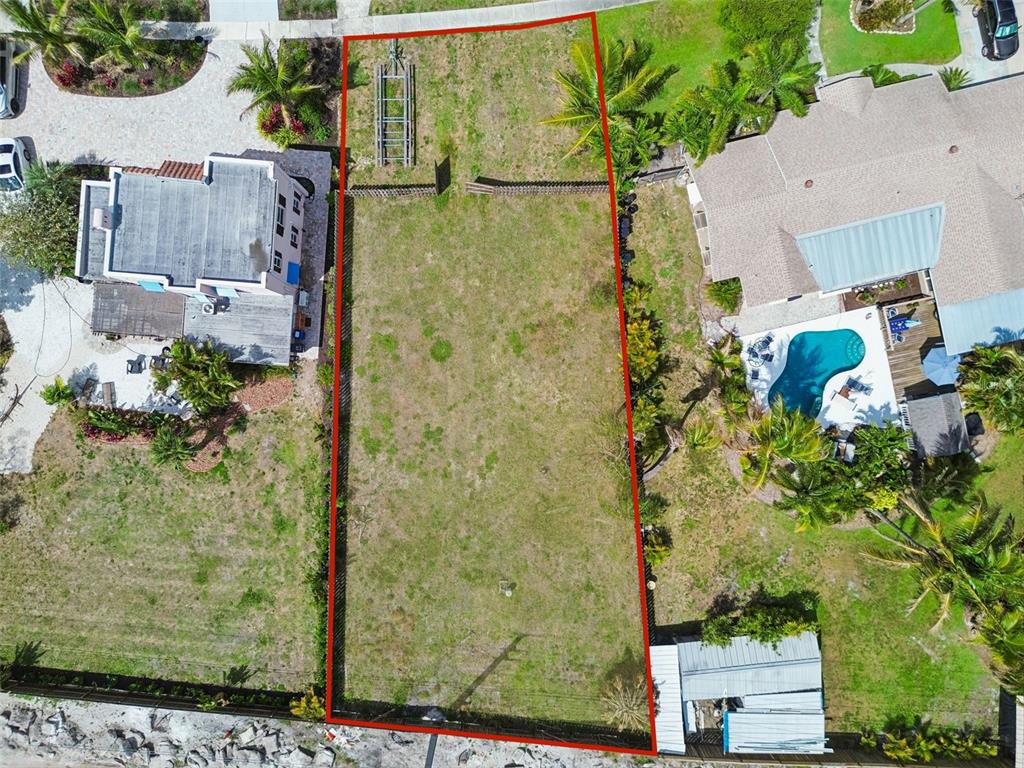 An aerial view shows a vacant, rectangular residential lot outlined in red between two houses — 603 CASABELLA DRIVE, BRADENTON, FL