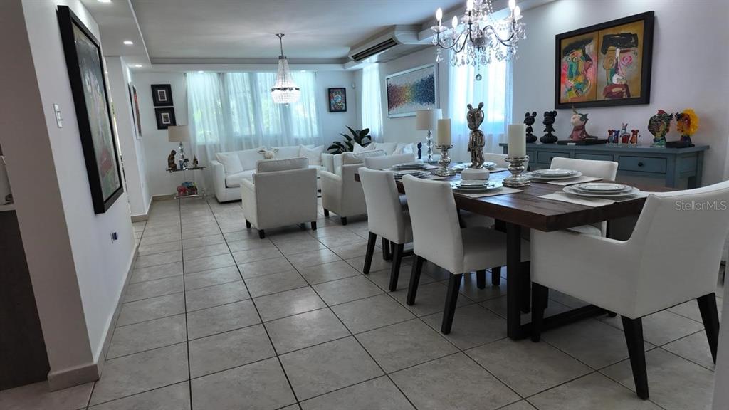 A dining area and living room feature white furniture, tile floors, and crystal chandeliers — 623 MAR DE BERING, DORADO, PR