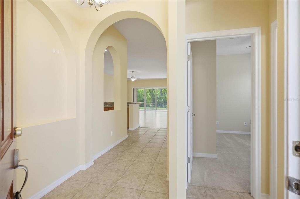 A room with wood-look flooring and sliding glass doors opening to a screened-in patio — 144 MENDOZA CIRCLE, DAYTONA BEACH, FL