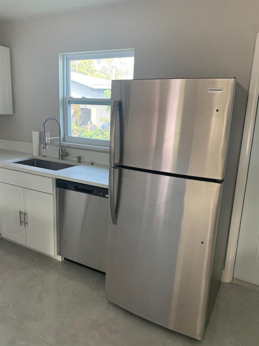 A kitchen features white cabinets, a stainless steel dishwasher, and a stainless steel refrigerator — 3195 Mcsherry Drive S # 3195, Lake Worth FL 33461, LAKE WORTH, FL