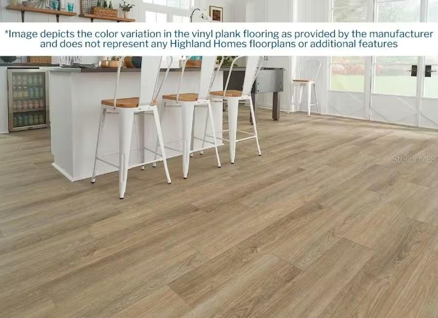 A kitchen with a white island, bar stools, and light wood-look vinyl plank flooring — 5125 SYLAS JAX AVENUE, WINTER HAVEN, FL