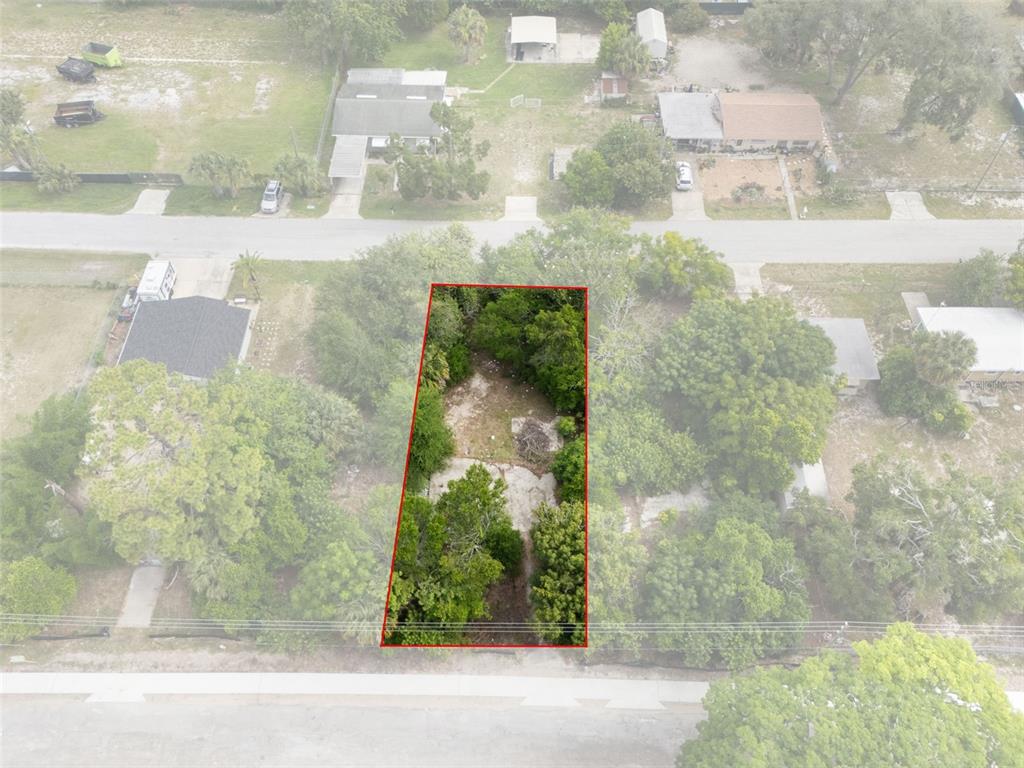 An aerial view shows a rectangular, tree-covered vacant lot outlined in red — 7039 JOHNSON ROAD, PORT RICHEY, FL
