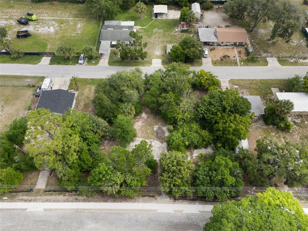 An aerial view shows a vacant, tree-covered lot situated between two residential properties — 7039 JOHNSON ROAD, PORT RICHEY, FL