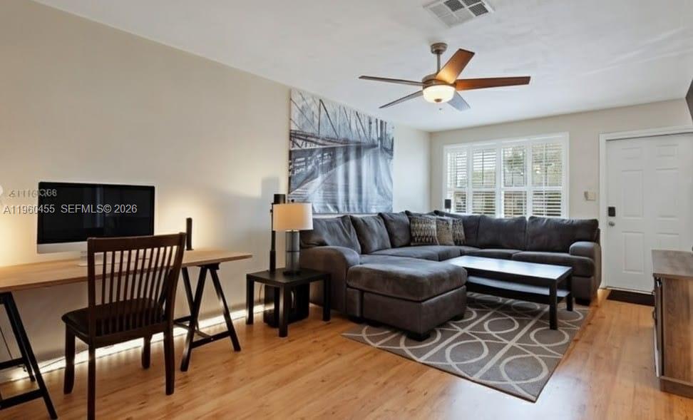 A living room features a sectional sofa, a desk with a computer, and wood flooring — 8069 SW 19th Ct, Davie FL 33324, DAVIE, FL
