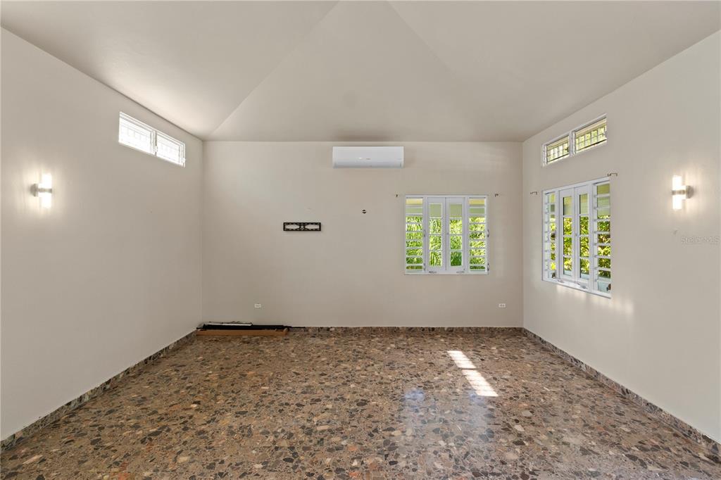 An empty room with terrazzo flooring, white walls, multiple windows, and a wall-mounted air conditioner — 1 EL MIRADOR DE SAN JUAN, SAN JUAN, PR