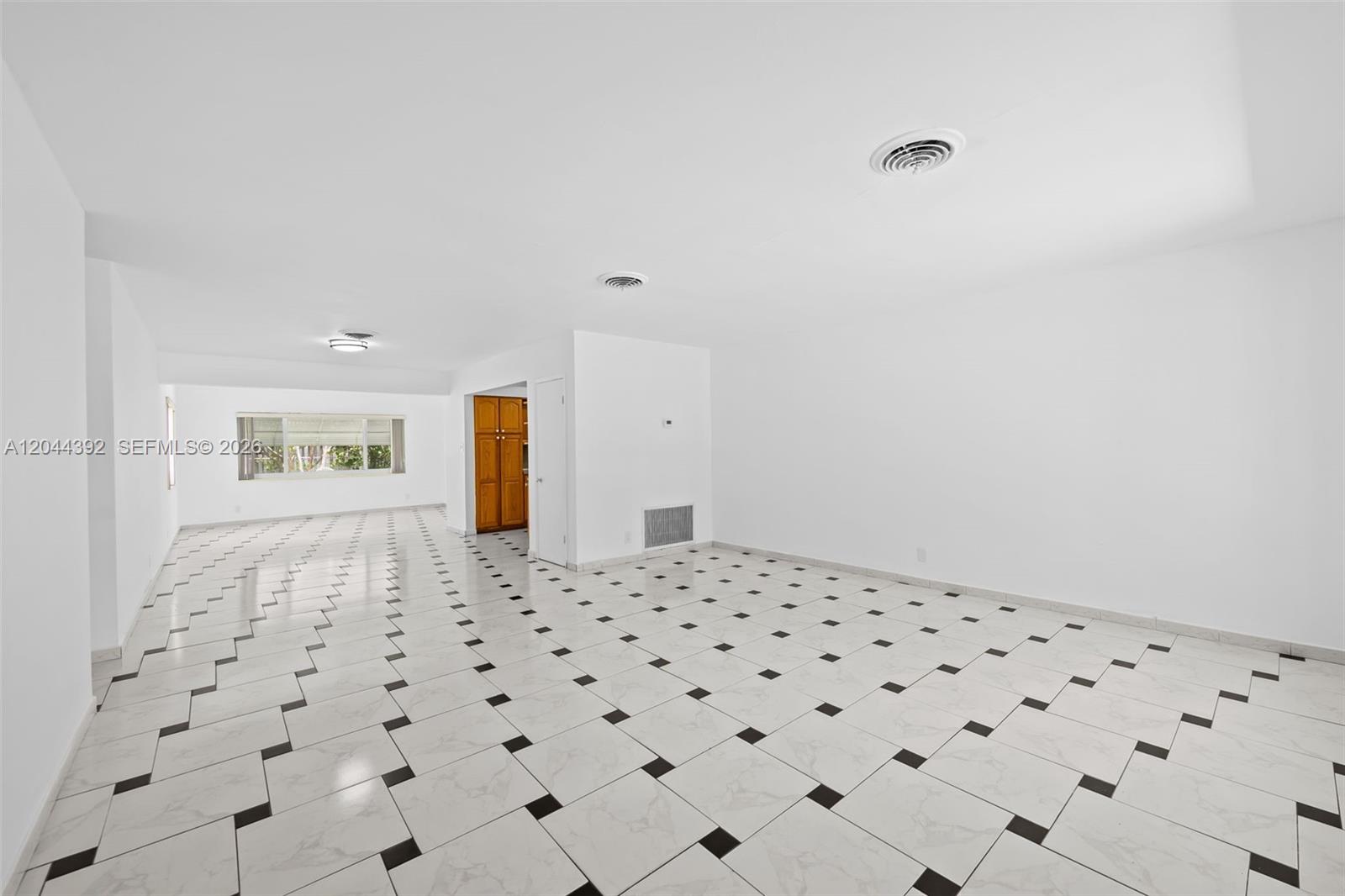 An empty room features white walls, a white ceiling with recessed lighting, and tiled flooring — 733 N Rainbow Dr, Hollywood FL 33021, HOLLYWOOD, FL
