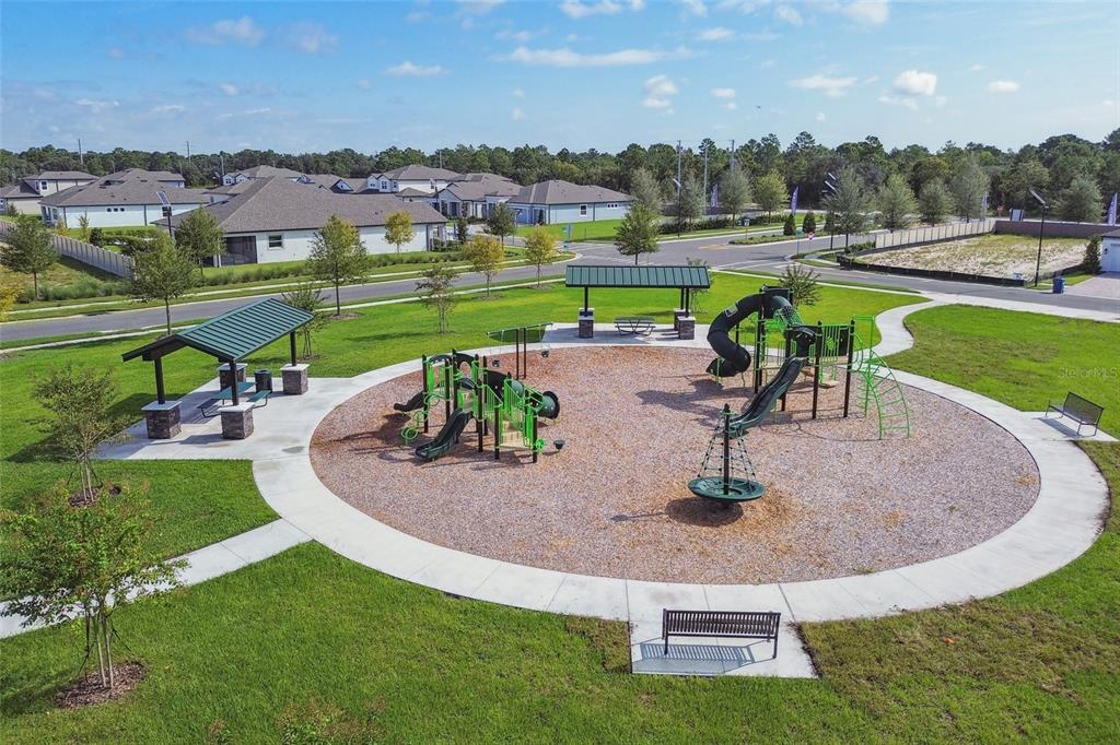 An aerial view of a neighborhood playground featuring play structures, benches, and covered picnic areas — 2172 CLARY SAGE DRIVE, SPRING HILL, FL