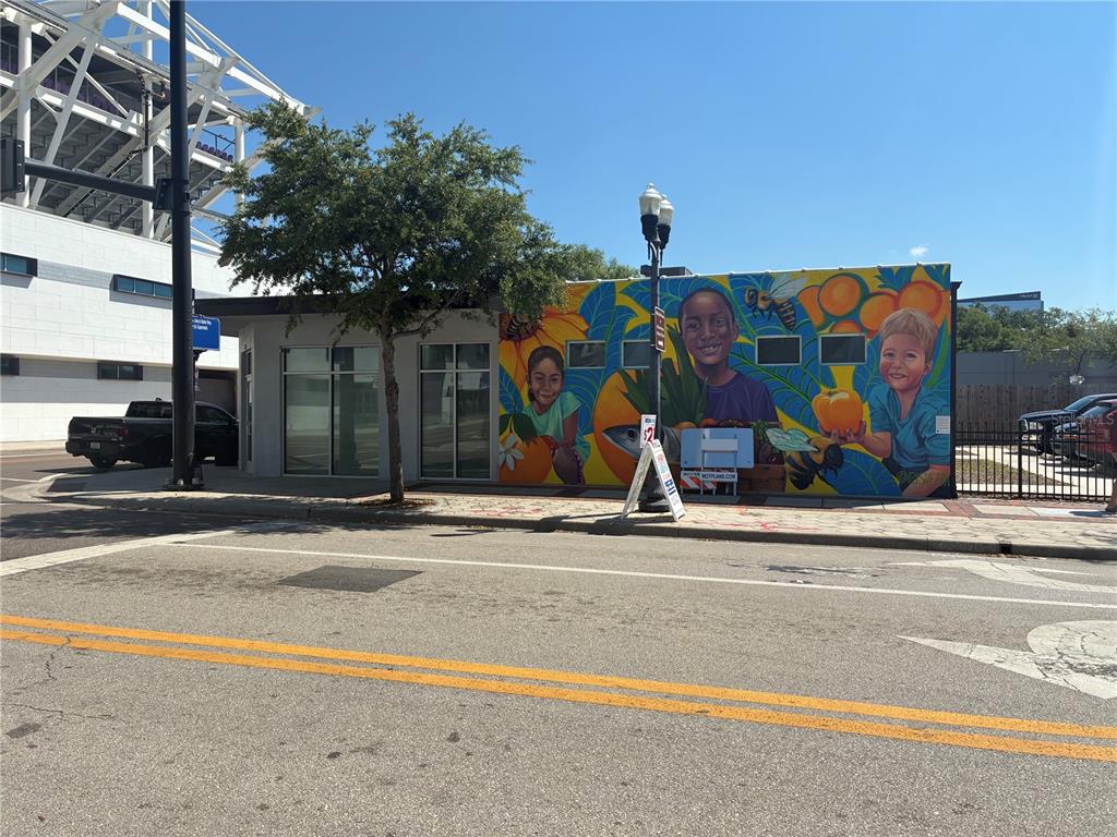 A single-story commercial building features a colorful mural of children and fruit on its exterior — 646 W CHURCH STREET, ORLANDO, FL