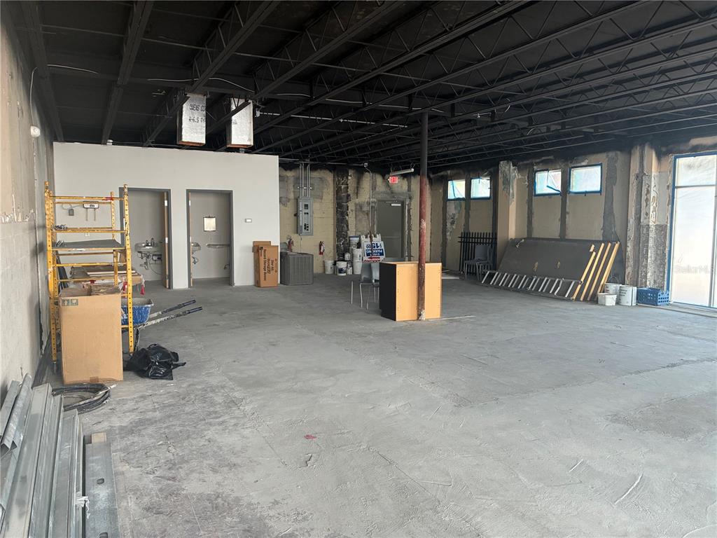 An unfinished commercial space features exposed ceiling joists, concrete floors, and two interior doorways — 646 W CHURCH STREET, ORLANDO, FL
