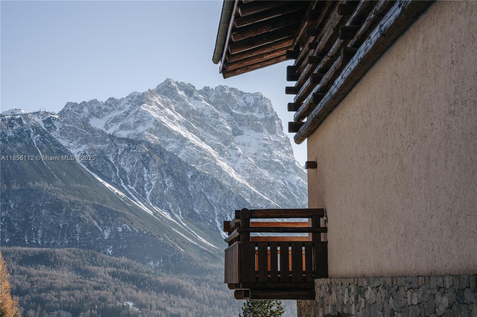 A wooden balcony extends from a stone and stucco building overlooking a snow-capped mountain range — Loc. Gilardon 57, Cortina Località Gilardon, FL, FL
