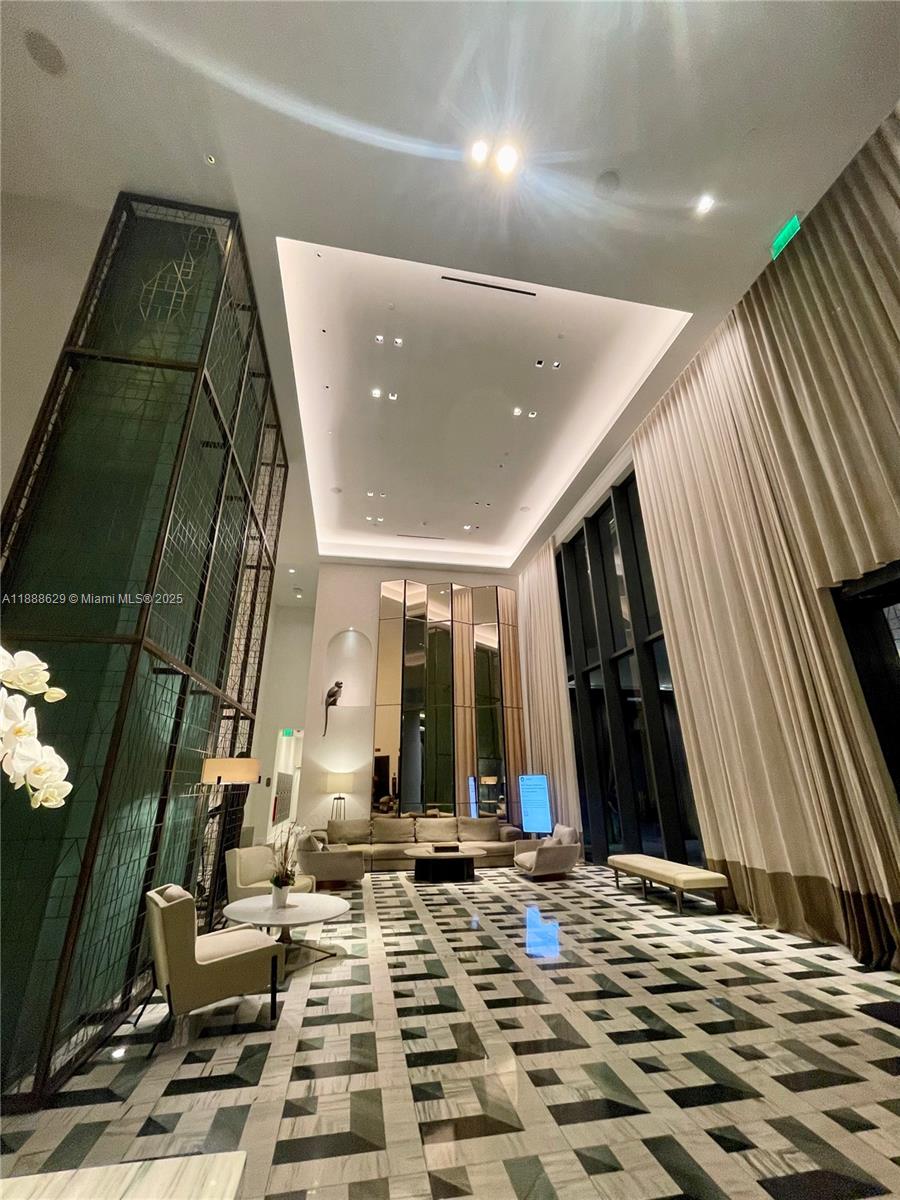 A modern lobby features high ceilings, floor-to-ceiling curtains, and a geometric patterned floor — 801 S Miami Ave # 3304, Miami FL 33130, MIAMI, FL