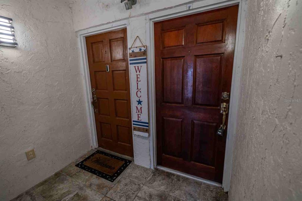 An open-concept kitchen with dark wood cabinets and a dining area with tile flooring — 225 COUNTRY CLUB DRIVE UNIT D142, LARGO, FL