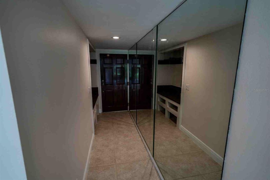 A spacious room with tile flooring, a ceiling fan, and an adjacent kitchen area — 225 COUNTRY CLUB DRIVE UNIT D142, LARGO, FL
