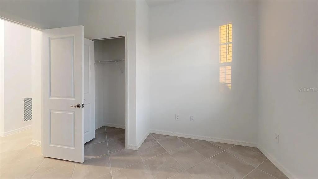 A room with light-colored walls, tile flooring, a closet, and a window with blinds — 2017 GARDENIA AVENUE, PORT CHARLOTTE, FL