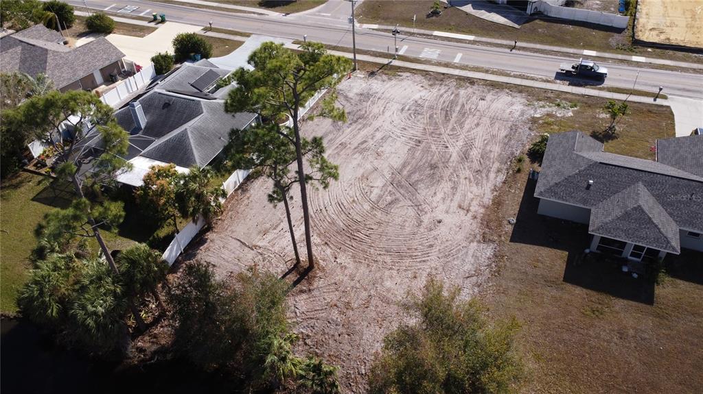 An aerial view shows a cleared, vacant residential lot situated between two existing houses — 23326 PEACHLAND BOULEVARD, PORT CHARLOTTE, FL
