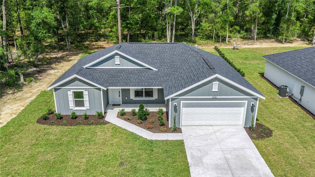 An aerial view of a gray single-story house with a white garage and dark roof — 4056 SW 156TH COURT, OCALA, FL