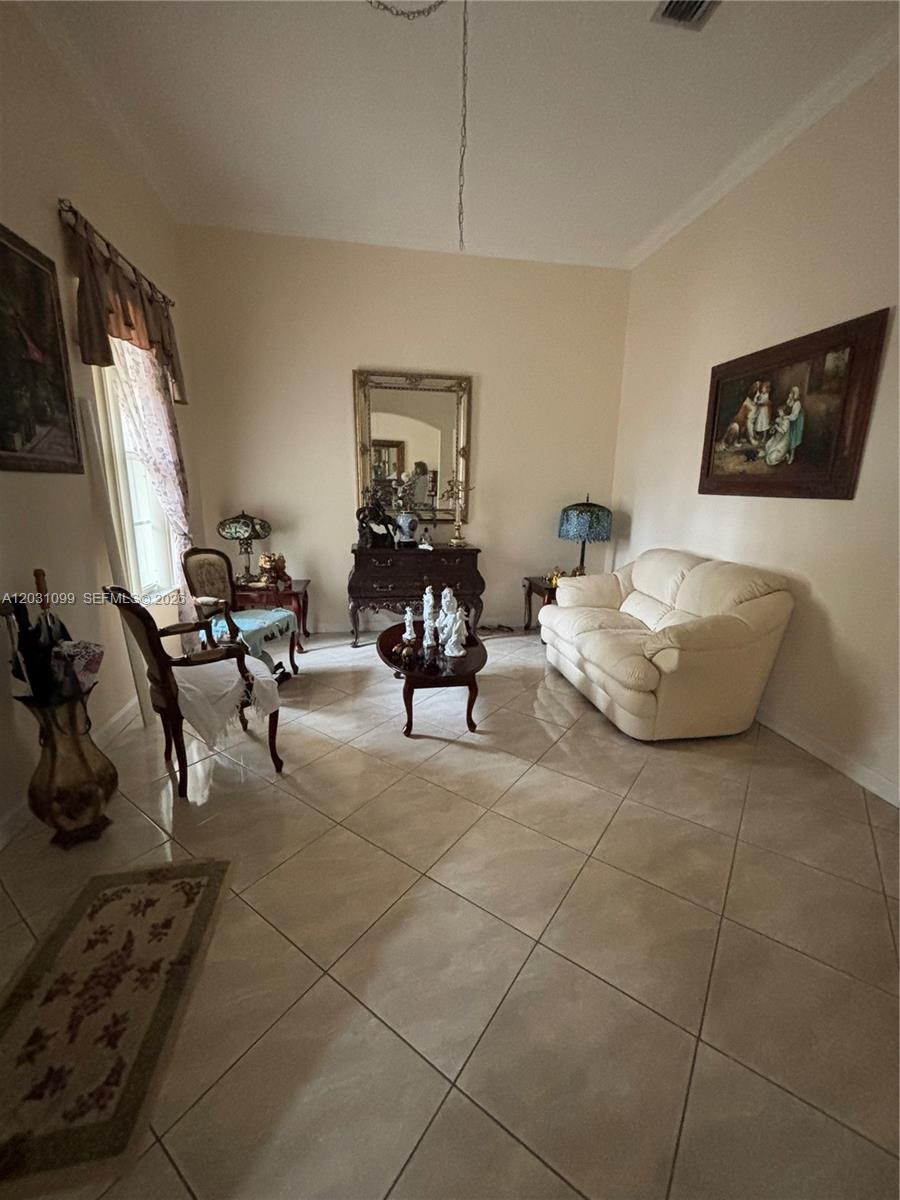 A living room features tile flooring, a white sofa, two chairs, and a central coffee table — 2103 NE 38th Rd, Homestead FL 33033, HOMESTEAD, FL