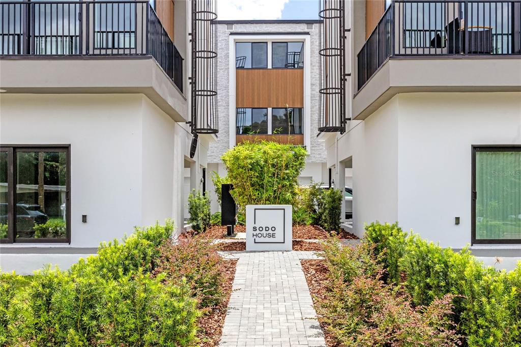 A paved walkway leads to a sign for Sodo House between two modern residential buildings — 52 W HARDING STREET UNIT A, ORLANDO, FL