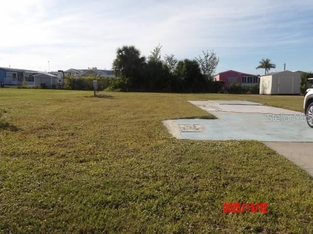 A grassy vacant lot features a concrete pad and a small shed in the background — 1538 BLUE HERON DRIVE, ENGLEWOOD, FL