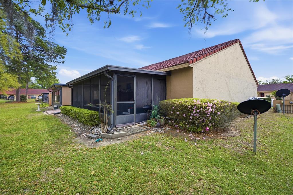A view of the back of a house with a screened-in porch and tiled roof — 3455 SW 19TH STREET, OCALA, FL