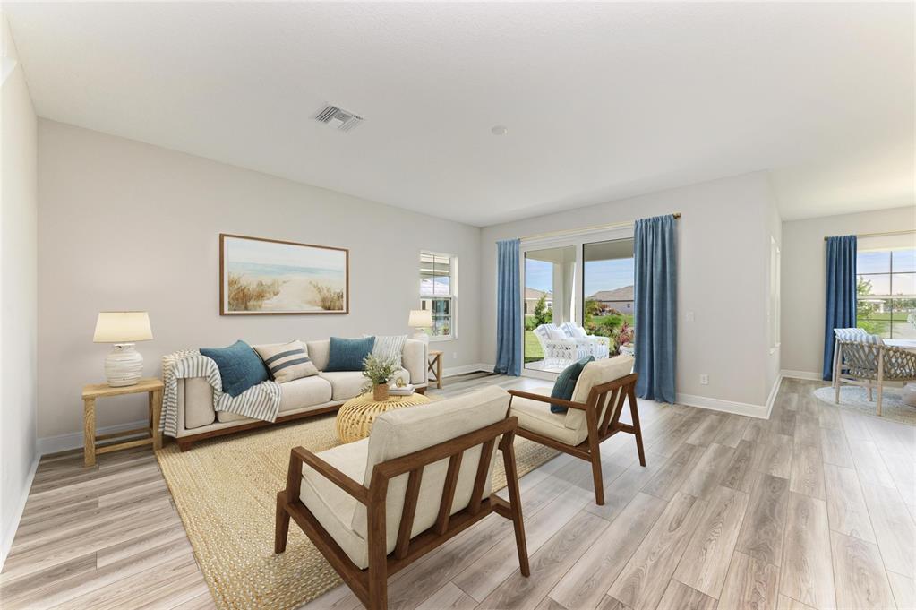 A living room features light wood flooring, a beige sofa, two armchairs, and sliding glass doors — 10148 SURREY ROSE DRIVE, SAN ANTONIO, FL