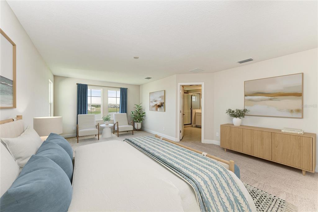 A bedroom features a bed, two armchairs by a window, and a wooden media console — 10148 SURREY ROSE DRIVE, SAN ANTONIO, FL