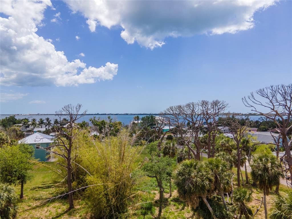 An elevated view of a coastal landscape featuring trees, houses, and a body of water — W COWLES STREET, ENGLEWOOD, FL