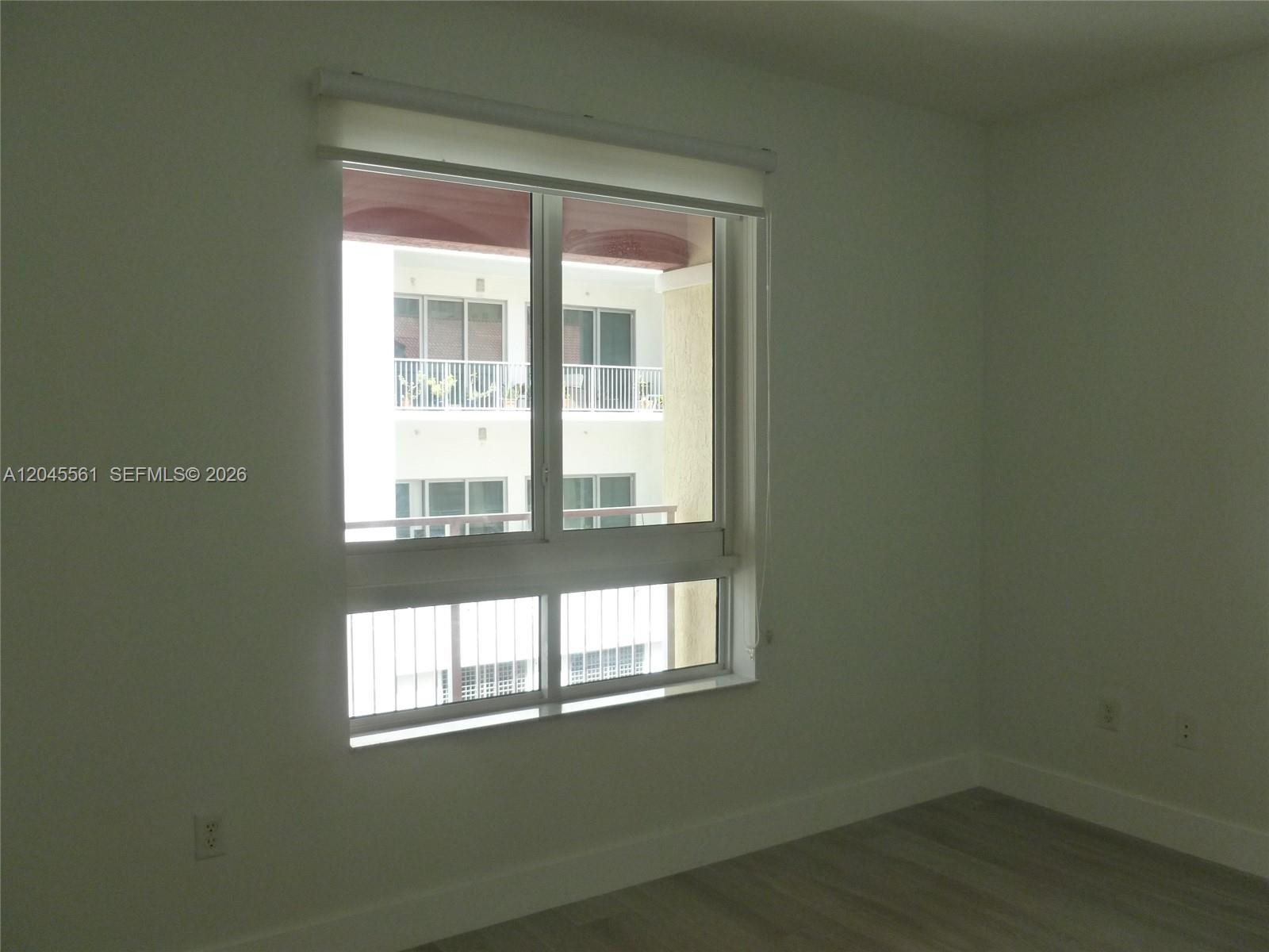 A room with light-colored flooring and a window overlooking a neighboring building's balcony — 7350 SW 89th St # 807S, Miami FL 33156, MIAMI, FL