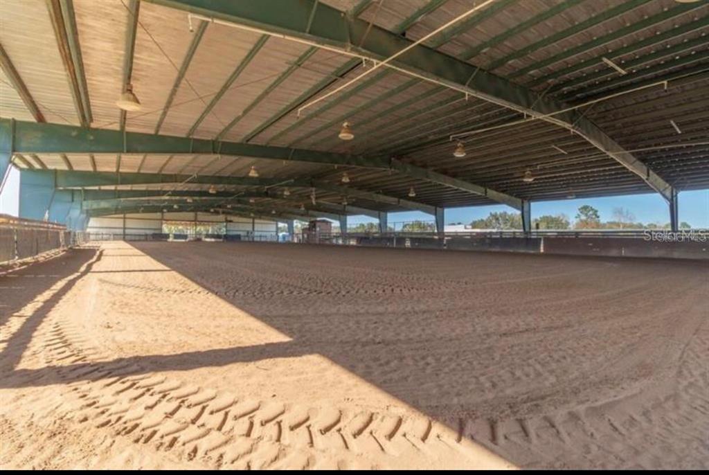 A large, covered outdoor equestrian riding arena with a sand floor and metal roof structure — 40812 GRAYS AIRPORT ROAD, LADY LAKE, FL