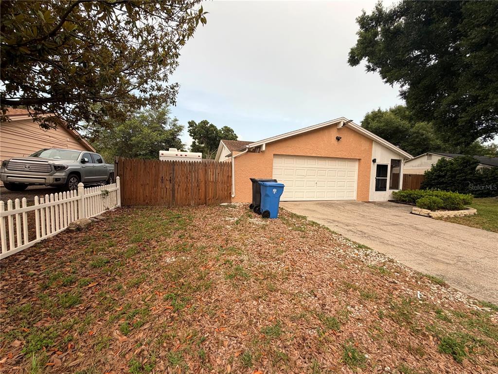 A single-story house with a peach-colored exterior, a two-car garage, and a concrete driveway — 2206 PAVILION PLACE, BRANDON, FL