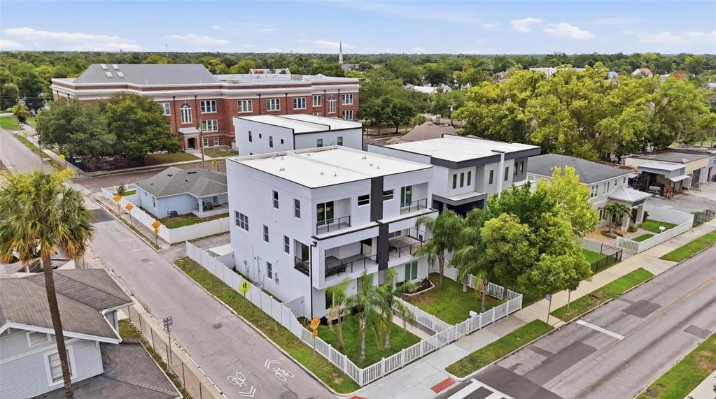 A modern three-story white townhouse features balconies, palm trees, and a white picket fence — 215 W COLUMBUS DRIVE UNIT 2, TAMPA, FL