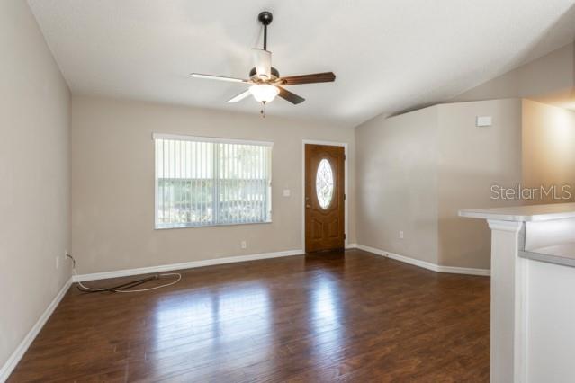 A living room with wood-look flooring, a ceiling fan, and a front door — 3 PINE HAVEN DRIVE, PALM COAST, FL
