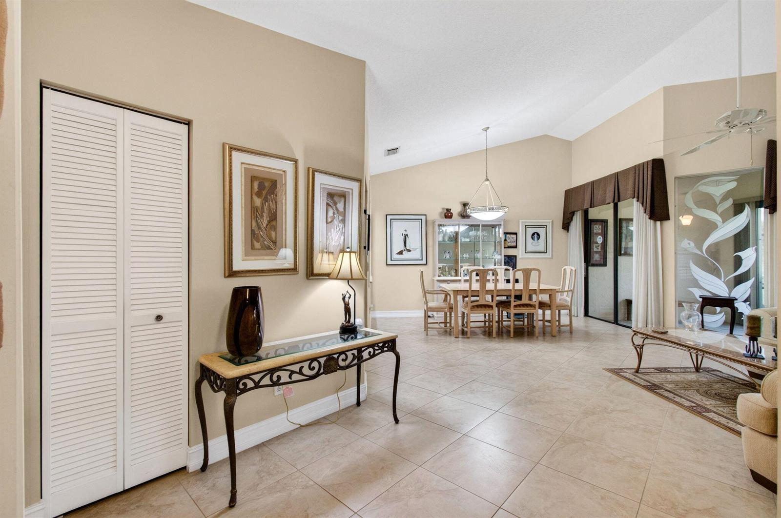 A tiled entryway leads into a dining area with vaulted ceilings and a glass table — 7481 Hearth Stone Avenue, Boynton Beach FL 33472, BOYNTON BEACH, FL