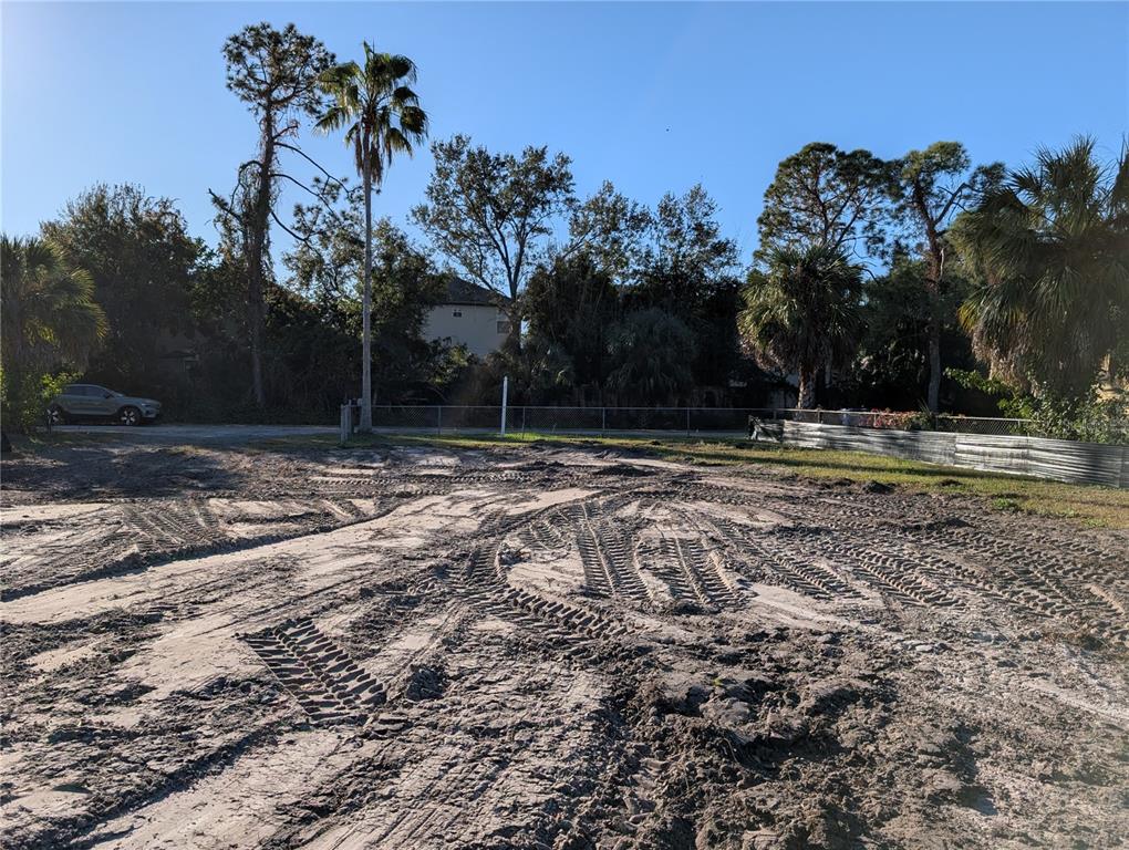 A vacant, sandy construction lot features tire tracks and surrounding trees under a clear sky — 1331 MENTONE DRIVE NE, ST PETERSBURG, FL