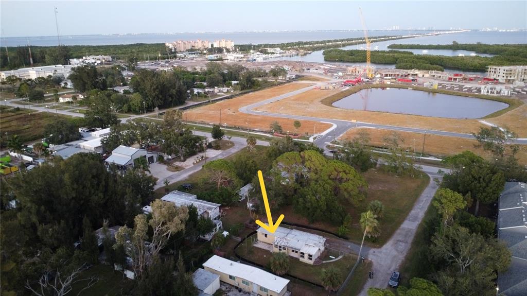 An aerial view shows a single-story house with a yellow arrow pointing to its roof — 1331 MENTONE DRIVE NE, ST PETERSBURG, FL