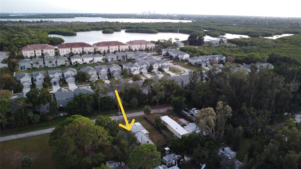 An aerial view shows a single-story house with a yellow arrow pointing toward it — 1331 MENTONE DRIVE NE, ST PETERSBURG, FL