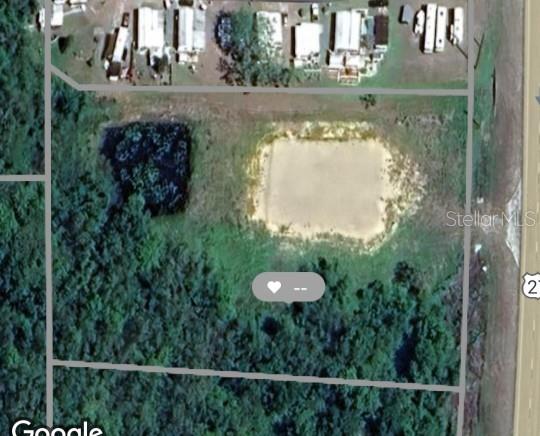 This aerial map shows a rectangular plot of land featuring a pond and wooded area — US HWY 27 S, LAKE WALES, FL