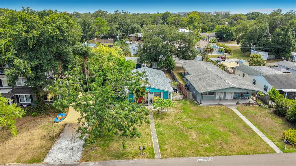An aerial view shows two adjacent houses with a large tree and a shaded driveway — 5710 19TH AVENUE S, GULFPORT, FL