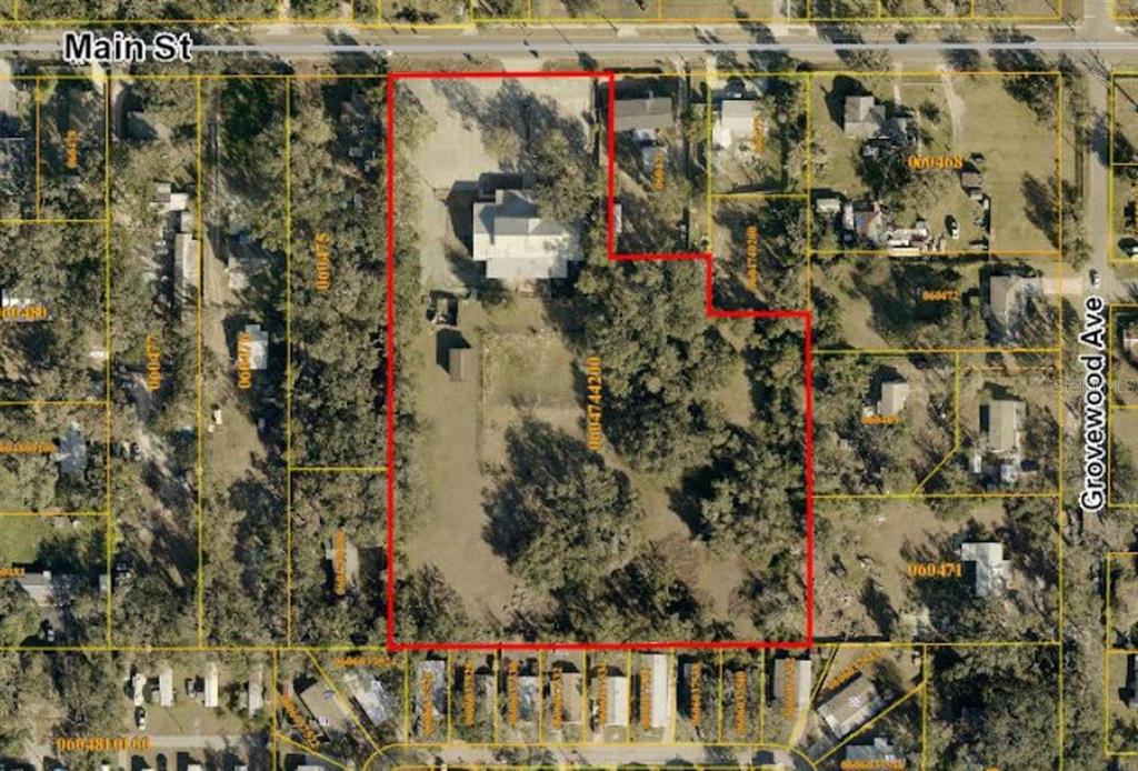 This aerial map shows a large, irregularly shaped residential lot with a house and trees — 10511 MAIN STREET, THONOTOSASSA, FL