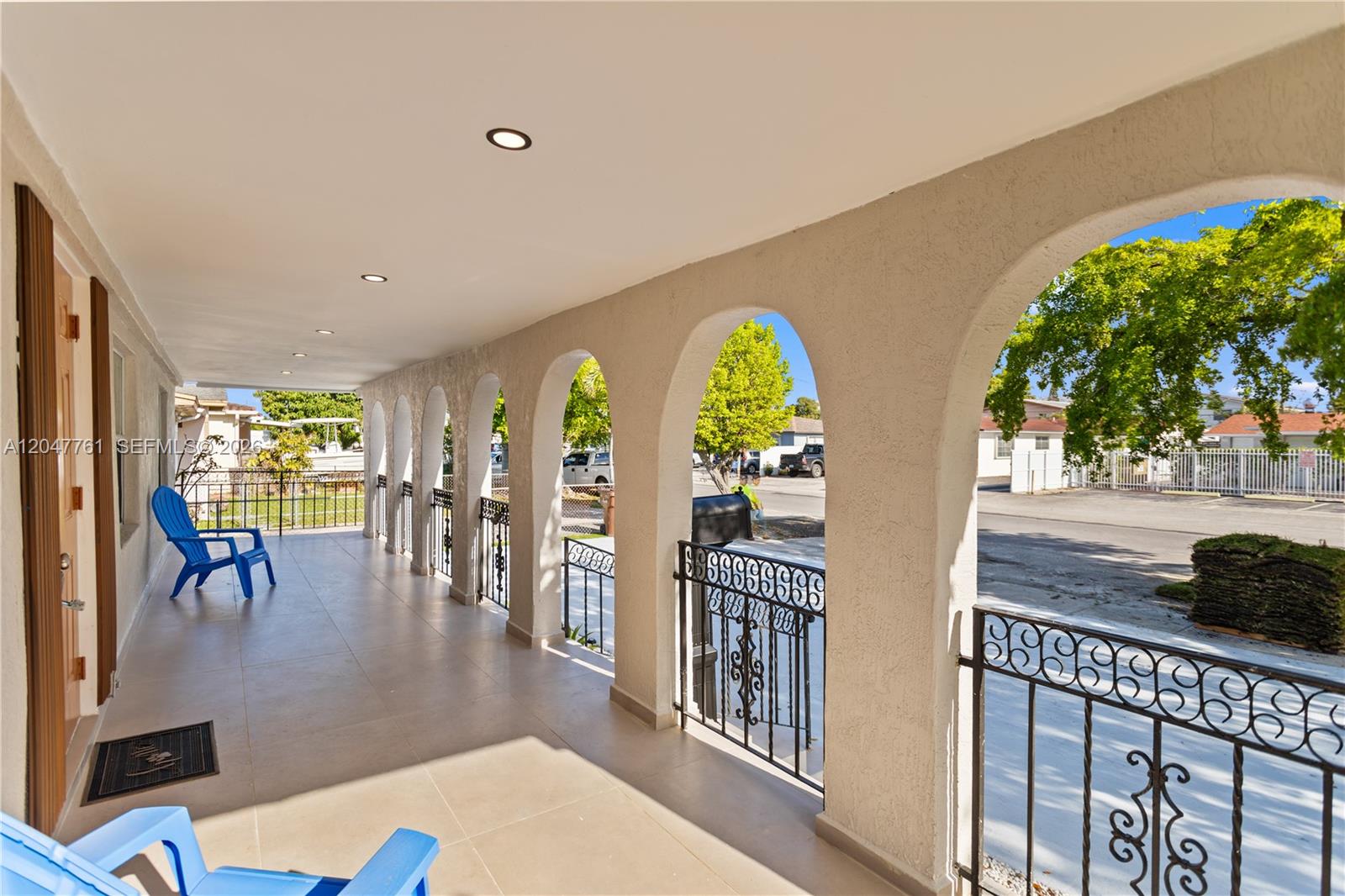 A covered porch features arched openings, wrought iron railings, and light-colored tile flooring — 171 W 13th St # 171, Hialeah FL 33010, HIALEAH, FL