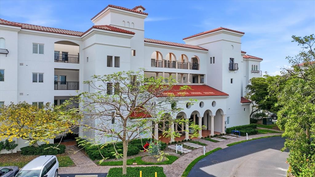 A multi-story white stucco apartment building features a red tile roof and arched entryways — 11160 HACIENDA DEL MAR BOULEVARD UNIT 202, PLACIDA, FL