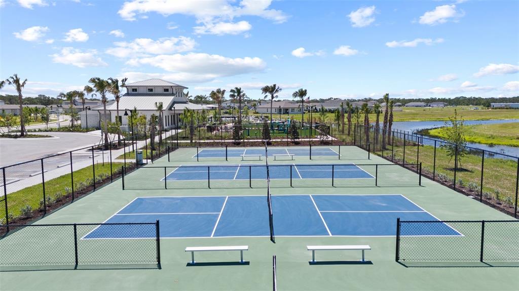 An elevated view of two outdoor pickleball courts with blue surfaces and surrounding chain-link fencing — 282 HOLLY BANK AVENUE, NOKOMIS, FL