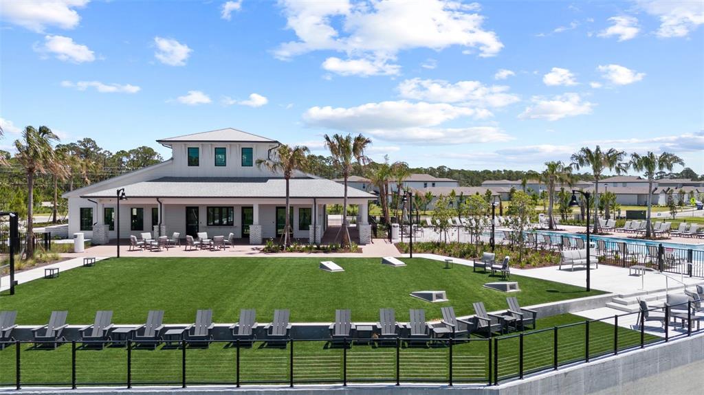 An outdoor community space features a clubhouse, artificial turf lawn, and rows of lounge chairs — 282 HOLLY BANK AVENUE, NOKOMIS, FL
